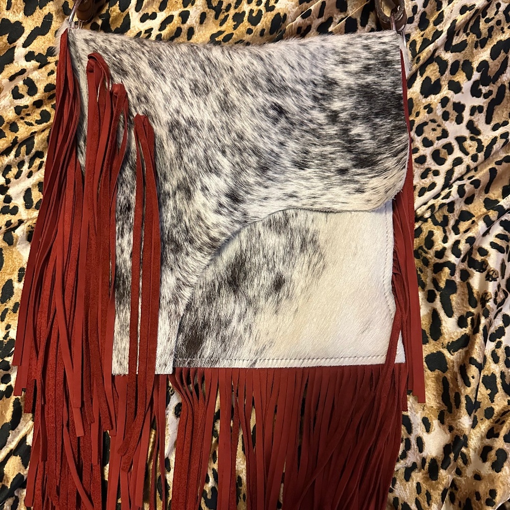 hair on hide bag with red suede fringe and tooled leather strap